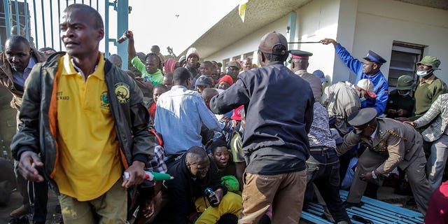 People are crushed in a stampede as security forces attempt to push them back, as they force their way into Kasarani stadium where the inauguration of Kenya's new president William Ruto is due to take place later today, in Nairobi, Kenya Tuesday, Sept. 13, 2022. 