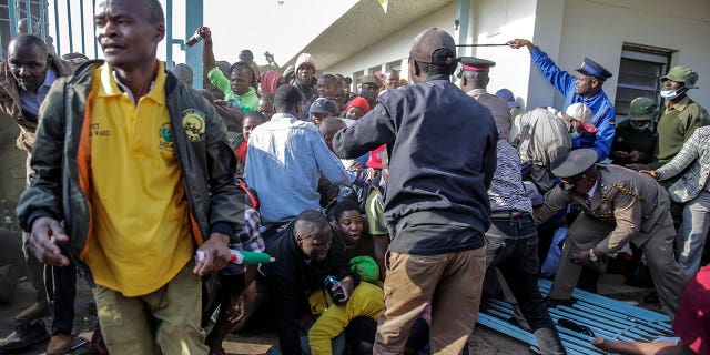 People are crushed in a stampede as security forces attempt to push them back, as they force their way into Kasarani stadium where the inauguration of Kenya's new president William Ruto is due to take place later today, in Nairobi, Kenya Tuesday, Sept. 13, 2022. 