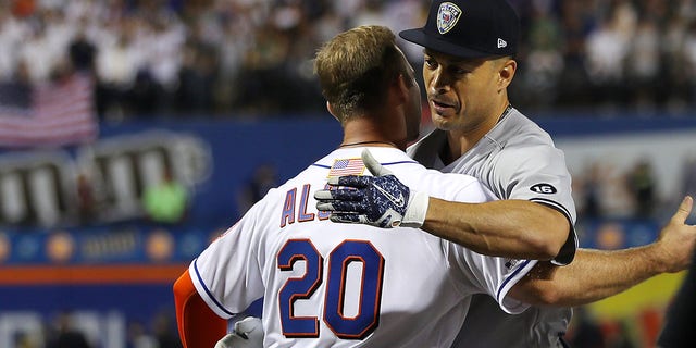 Giancarlo Stanton of the New York Yankees hugs Pete Alonso (20) of the New York Mets before their game at Citi Field in New York on Sept. 11, 2021.