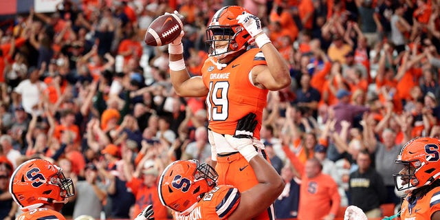 Matthew Bergeron #60 lifts Syracuse Orange's Oronde Gadsden II #19 after Gadsden II scored a touchdown during the fourth quarter against the Purdue Boilermakers at JMA Wireless Dome on September 17, 2022 in Syracuse, New York. 