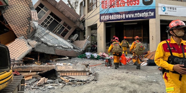 Des pompiers à la recherche de victimes piégées dans un immeuble résidentiel effondré à la suite d'un tremblement de terre dans le canton de Yuli, dans le comté de Hualien, dans l'est de Taïwan, le dimanche 18 septembre 2022. (Service d'incendie du comté de Hualien via AP)