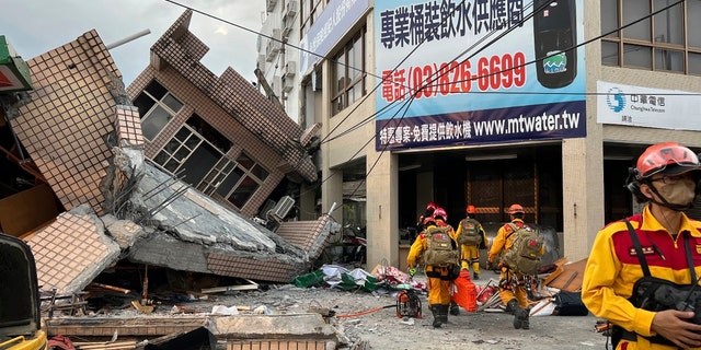 Firefighters search for victims trapped in collapsed houses after an earthquake struck Yuli Township, Hualien County, eastern Taiwan, Sunday, September 18, 2022.  (Hualien County Fire Department via AP)