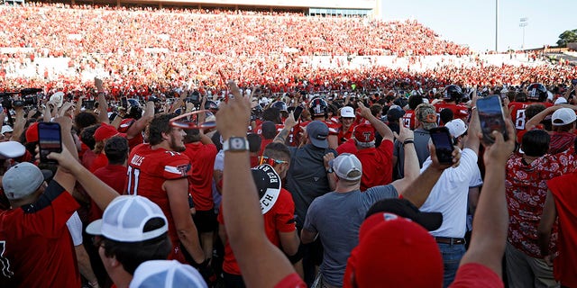 Texas Tech fans celebrate on the field after an NCAA college football game against Texas, Saturday, Sept. 24, 2022, in Lubbock, Texas.