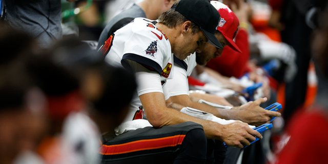 Tom Brady of the Tampa Bay Buccaneers looks at a tablet during the Saints game at Caesars Superdome on Sept. 18, 2022, in New Orleans.