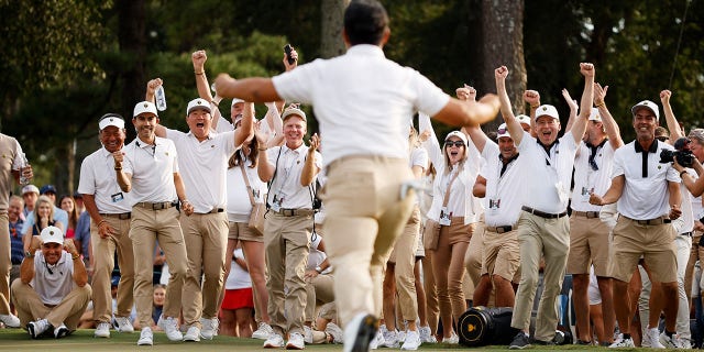 The International Team cheers as Tom Kim of South Korea and the International Team celebrates his hole-winning putt to win the match 1 Up with teammate Si Woo Kim of South Korea against Patrick Cantlay and Xander Schauffele on Sept. 24, 2022 in Charlotte, North Carolina.