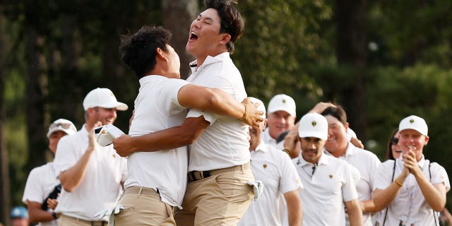 Tom Kim of South Korea and Si Woo Kim of South Korea and the International Team celebrate Tom Kim's hole-winning putt on Sept. 24, 2022 in Charlotte, North Carolina.