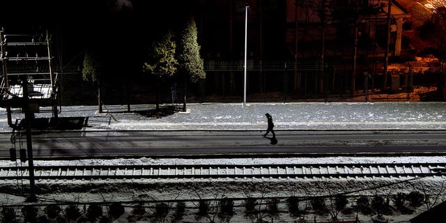 Pictured: A Chinese soldier walks along train tracks in the border city of Dandong in China's northeast Liaoning province on Jan. 10, 2018.