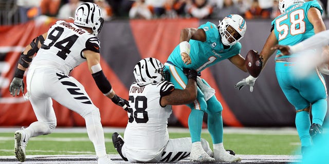 Quarterback Tua Tagovailoa #1 of the Miami Dolphins is sacked by defensive tackle Josh Tupou #68 of the Cincinnati Bengals during the 2nd quarter of the game against the Cincinnati Bengals at Paycor Stadium on September 29, 2022 in Cincinnati, Ohio.