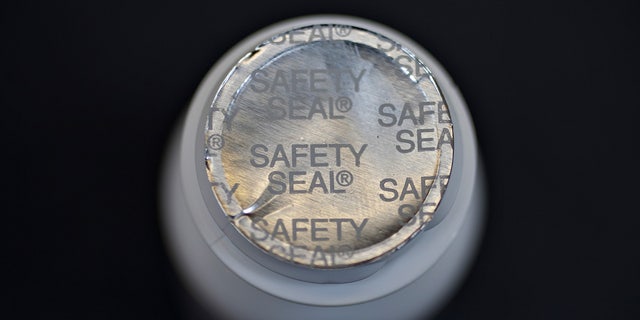 The top of an opened bottle showing a silver safety seal.