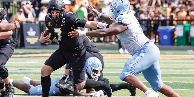 Appalachian State quarterback Chase Brice (7) runs past North Carolina defensive lineman Myles Murphy (8) during the second half of an NCAA college football game, Saturday Sept. 3, 2022, in Boone, N.C.