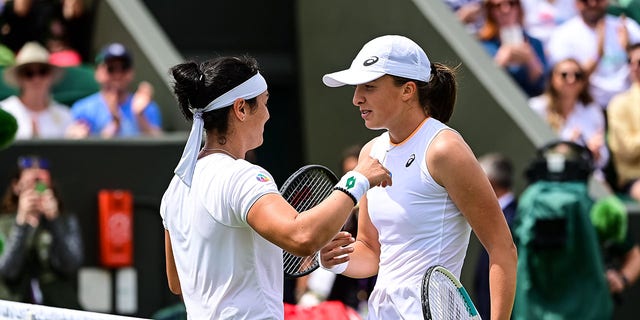 Ons Jabeur of Tunisia embraces  Iga Swiatek of Poland after beating her in the fourth round of the ladies singles during Day Seven of The Championships - Wimbledon 2021 at All England Lawn Tennis and Croquet Club on July 05, 2021 in London, England.