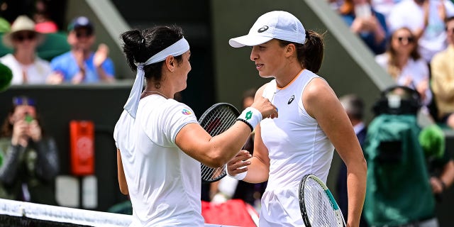 Ons Jabeur of Tunisia embraces  Iga Swiatek of Poland after beating her in the fourth round of the ladies singles during Day Seven of The Championships - Wimbledon 2021 at All England Lawn Tennis and Croquet Club on July 05, 2021 in London, England.