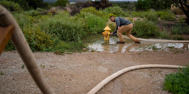 Garnett Querta fills his water truck from a fire hydrant on the Hualapai reservation in Peach Springs, Arizona, on Aug. 15, 2022.