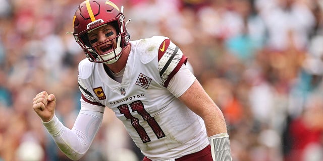 Washington Commanders quarterback Carson Wentz celebrates after throwing a touchdown pass to wide receiver Jahan Dotson against the Jacksonville Jaguars at FedExField on September 11, 2022 in Landover, Maryland.