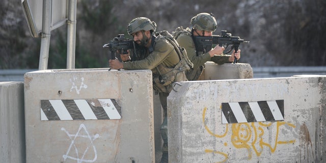Israeli soldiers take position at a roadblock near the West Bank town of Nablus, Saturday, Sept. 24 2022. Israeli troops on Saturday shot and killed a Palestinian motorist who allegedly tried to ram his car into a group of soldiers patrolling in the occupied West Bank, according to Israeli soldiers and media. (AP Photo/Majdi Mohammed)