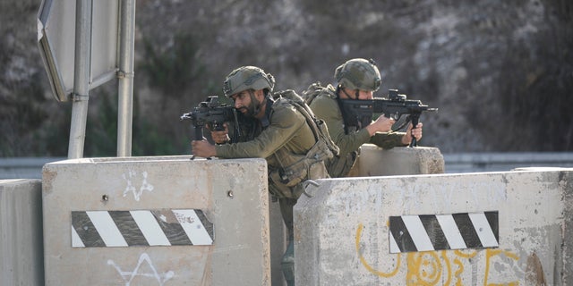 Israeli soldiers take position at a roadblock near the West Bank town of Nablus, Saturday, Sept. 24 2022. Israeli troops on Saturday shot and killed a Palestinian motorist who allegedly tried to ram his car into a group of soldiers patrolling in the occupied West Bank, according to Israeli soldiers and media. (AP Photo/Majdi Mohammed)