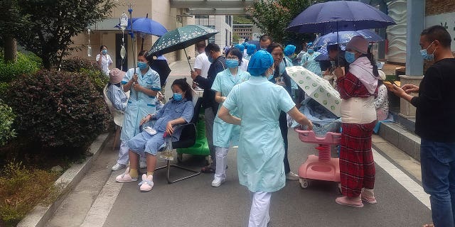 In this photo published by the Xinhua News Agency, health workers transfer patients to a safe area at the Shimian County Renmin Hospital in Ya'an City in the aftermath of an earthquake in Sichuan Province, Southwest China, Monday, September 5, 2022.