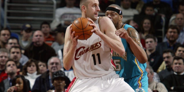 Zydrunas Ilgauskas #11 of the Cleveland Cavaliers posts up Sean Rooks #45 of the New Orleans Hornets during the game at Gund Arena on December 23, 2003 in Cleveland, Ohio.  The Cavaliers won 97-86. 