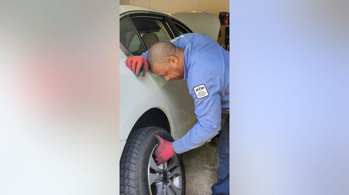 Carl Allamby working as a car mechanic