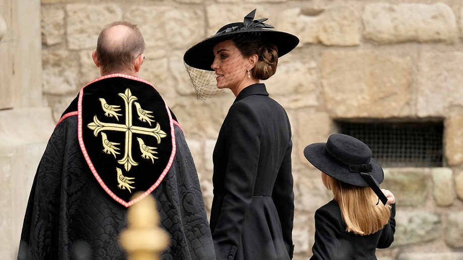 Kate Middleton, Princess of Wales, speaks to a clergyman at Westminster Abbey ahead of Queen Elizabeth's state funeral.