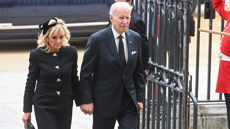 President Joe Biden and Jill Biden hold hands as they arrive at Westminster Abbey for Queen Elizabeth's state funeral