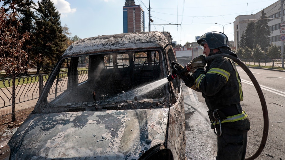 A firefighter extinguishes a burning vehicle after shelling in Donetsk
