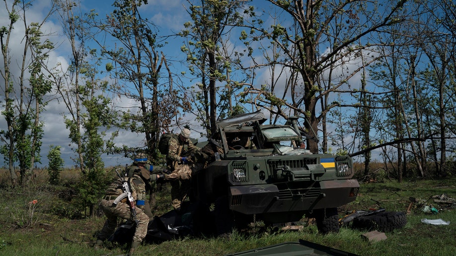 Ukrainian national guard servicemen remove the body of a Ukrainian soldier from an armored vehicle
