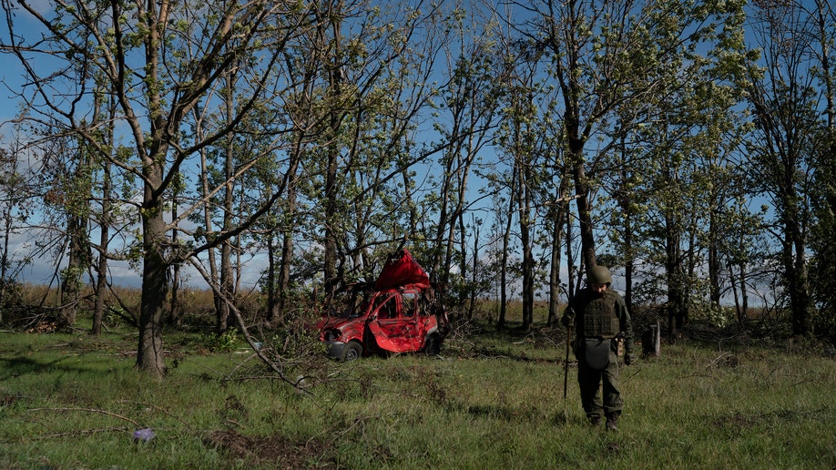 Ukrainian national guard serviceman checks for unexploded devices