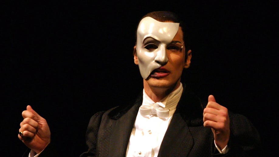 Man wearing a mask performs on stage