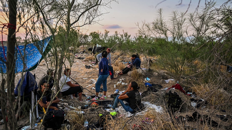 A photo of migrants who just crossed the border sitting down