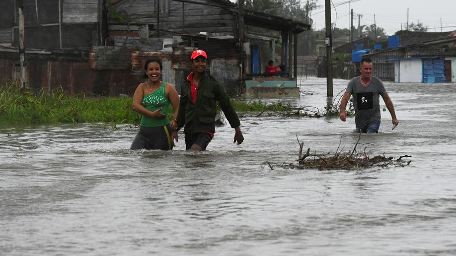 People walk through a flooded street in Batabano, Cuba