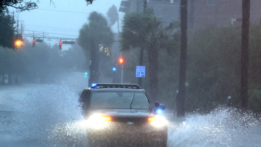Car drives down flooded street