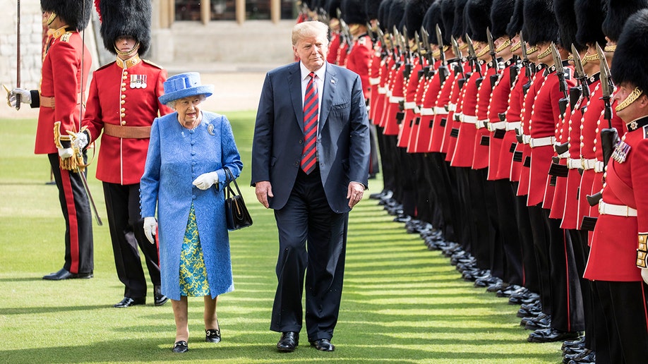 Queen Elizabeth II and Donald Trump walking near soldiers