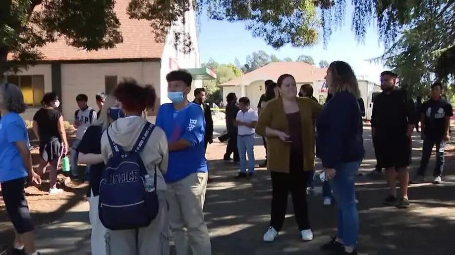 Parents and students congregate outside church where they are reuniting after Oakland school shooting on Wednesday.