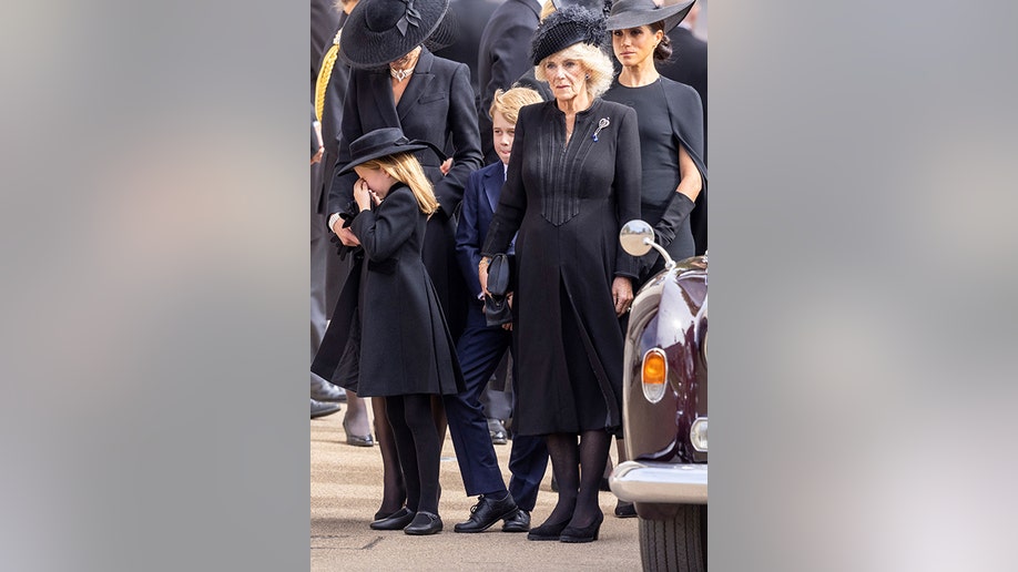 Princess Charlotte wipes her eyes during Queen Elizabeth's state funeral at Westminster Abbey.