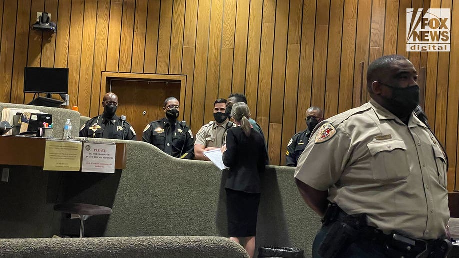 Cleotha Henderson in court with police around him