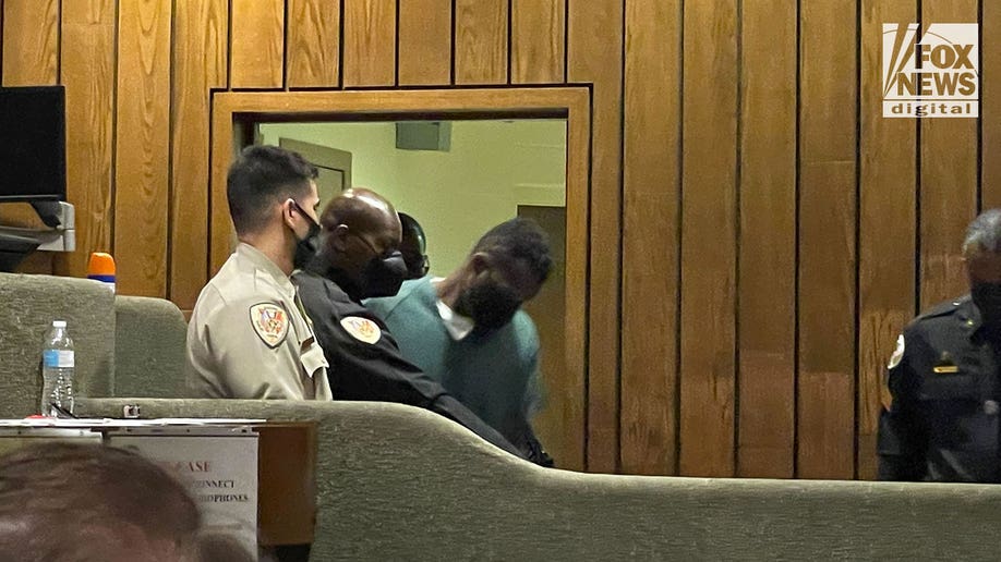 Murder suspect Cleotha Henderson wearing a green jumpsuit in court