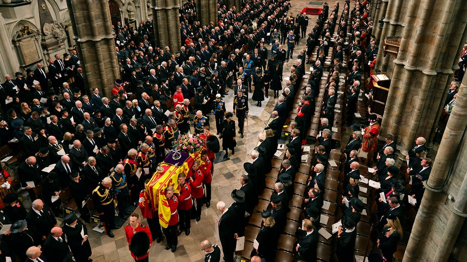 An overhead shot of the Royal Family, including King Charles and Queen Consort Camilla, following Queen Elizabeth's coffin into Westminster Abbey.