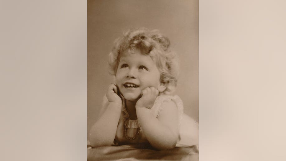 Toddler-aged Queen Elizabeth in a sepia colored photo