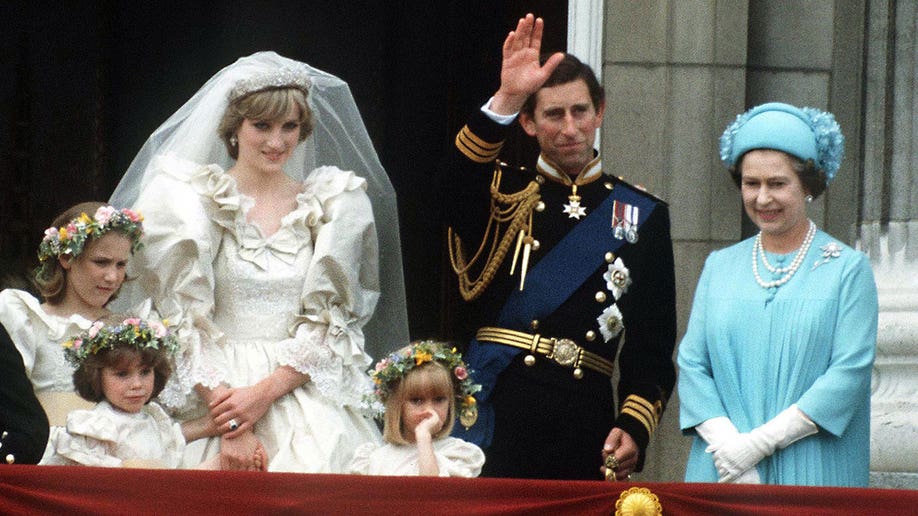 Princess Diana, Prince Charles, and Queen Elizabeth stand on the balcony of Buckingham palace during the Wales' wedding