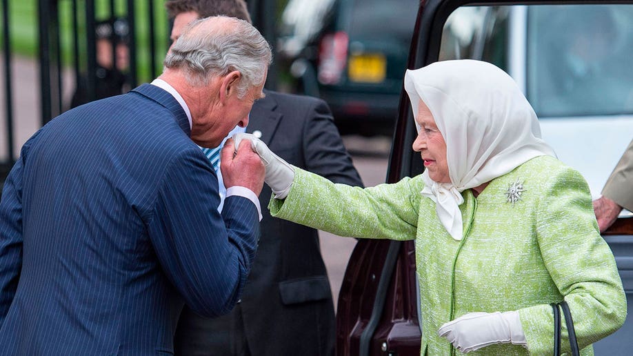Prince Charles kisses Queen Elizabeth's hand as she steps out of her car