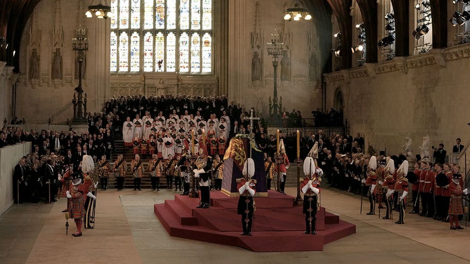 Queen Elizabeth's coffin is laid in state at Westminster Hall with a choir behind the coffin