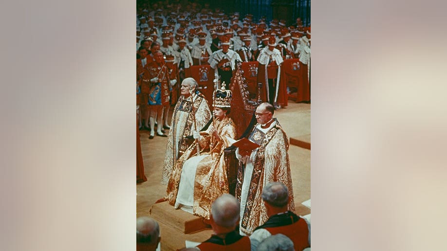 Queen Elizabeth in a large royal robe inside Westminster during her coronation ceremony