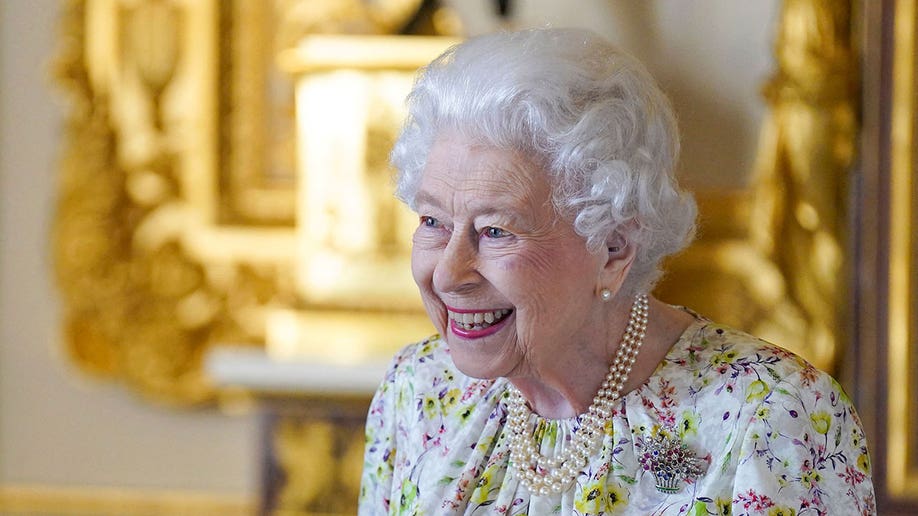 Queen wearing a floral dress smiling