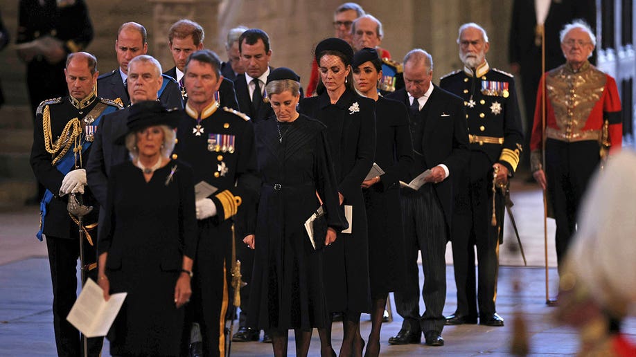 Royal family members dressed in black walk inside Westminster Hall
