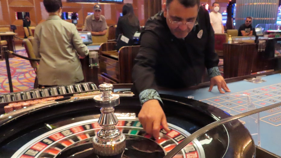 A dealer prepared to spin the ball during a game of roulette 