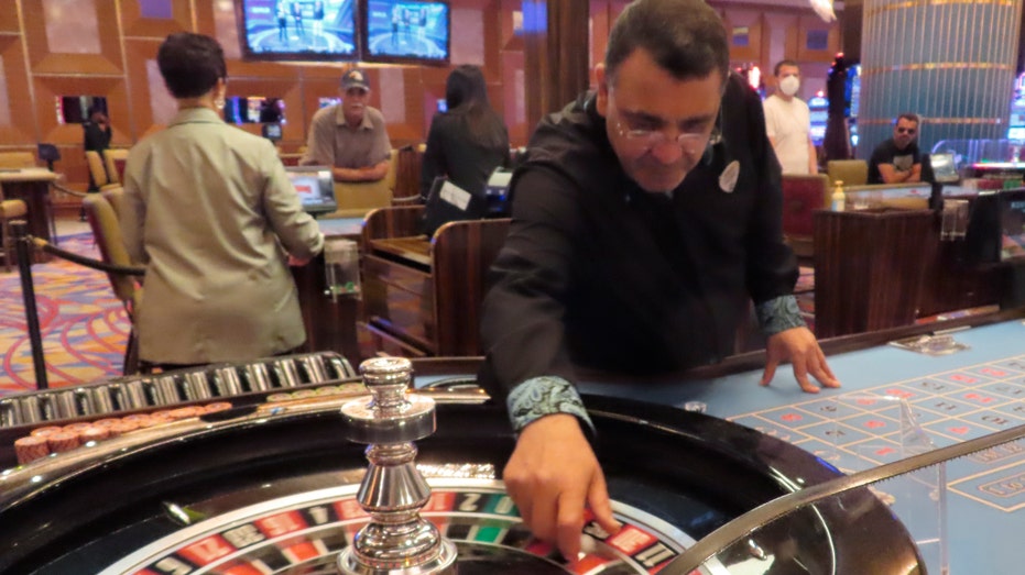 A dealer prepared to spin the ball during a game of roulette