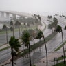 Wind gusts blow through palm trees forcing them to bend over highways as Hurricane Ian hits Florida