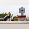 A Florida resident walks along a Florida beach during Hurricane Ian
