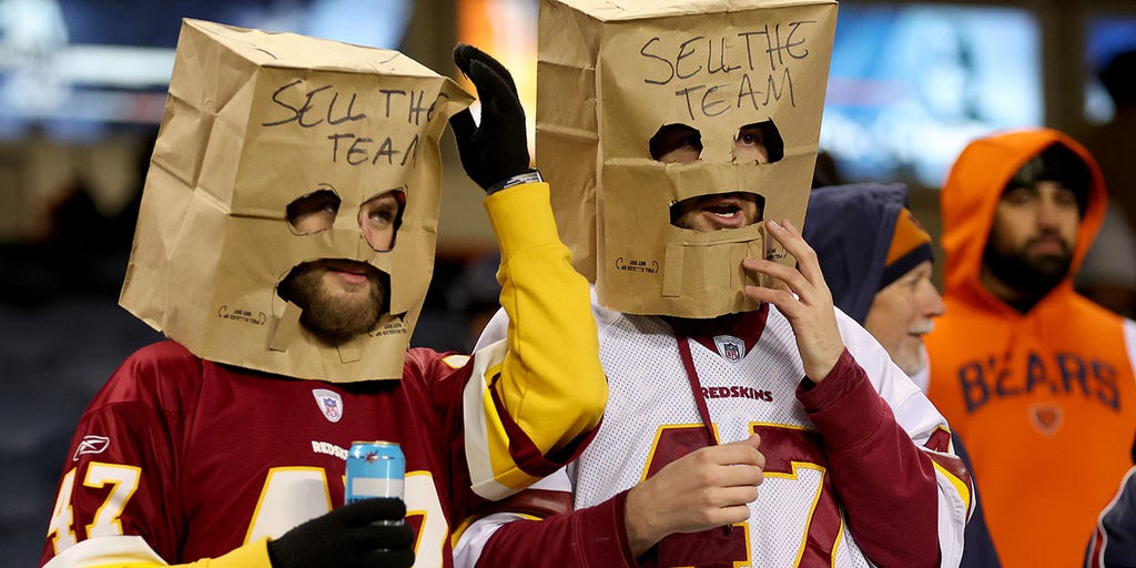 Commanders fans wear paper bags saying 'Sell The Team' amid owner